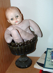 old doll in basket